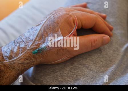 cannula di gocciolamento inserita nella mano di un paziente ospedaliero Foto Stock