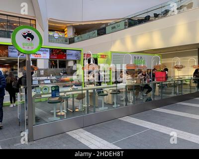 New Street Station e il ristorante Bull ring Birmingham mangiare cibo all'interno della parete in vetro divisorio cibi giapponesi posti a sedere clienti segno segni Wasabi Foto Stock