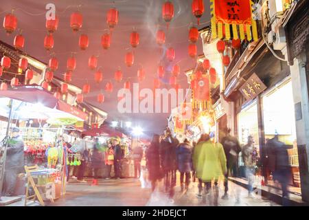 Luci al neon sulla strada. Il movimento offuscava la strada vecchia del turista cinese di notte con lanterne rosse. Foto Stock