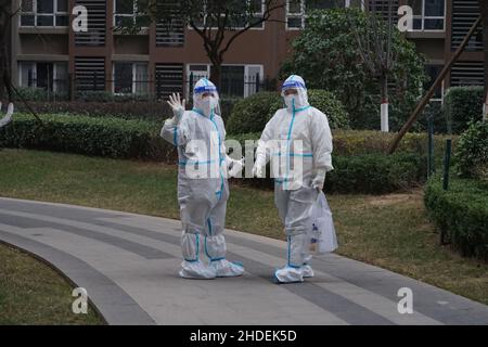 XI'AN, CINA - 6 GENNAIO 2022 - due operatori medici si preparano a condurre test sugli acidi nucleici su donne incinte in una comunità chiusa a Xi'an, Shaanxi Foto Stock