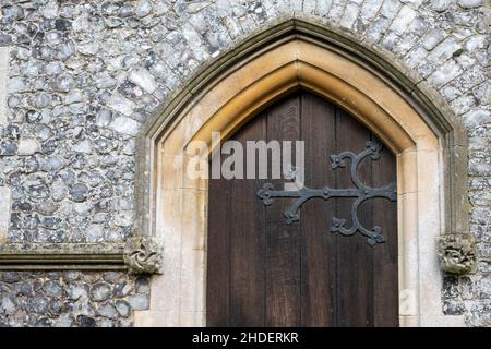 Fanghetta in pietra lungo il muro di selce a fondale sopra l'arco della porta a St Michael e All Angels, Boulge, Suffolk, UK Foto Stock