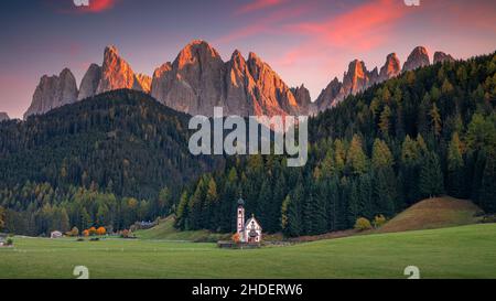 Autunno nelle Alpi. Immagine panoramica delle magiche montagne dolomitiche in una splendida Val di Funes, Alto Adige, Alpi Italiane al tramonto d'autunno. Foto Stock