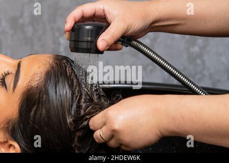 Parrucchiere lavaggio capelli donna in salone. Concetto di bellezza Foto Stock