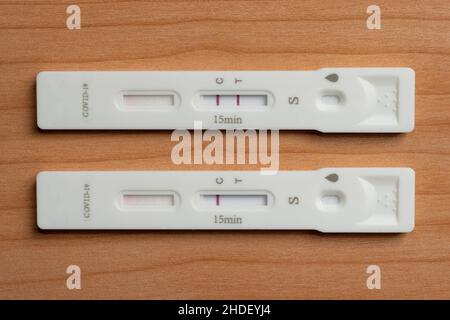 Due dispositivi di test rapido dell'antigene per il coronavirus covid-19 mostrano risultati positivi e negativi Foto Stock