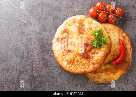 Chachapuri georgiano di grano appena sfornato con formaggio primo piano sul tavolo. Vista dall'alto orizzontale Foto Stock