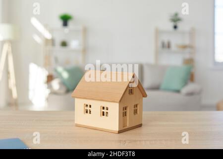 Primo piano di modello in miniatura di casa in legno posta sul tavolo nel soggiorno Foto Stock