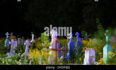 Vista sul cimitero della città ortodossa in estate di notte. Vecchie lapidi multicolore e croci. Foto Stock