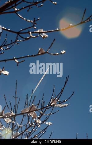 Un aereo da passeggeri a reazione lascia un contrail sulla sua scia mentre vola su un sudovest americano ghiacciato. Foto Stock