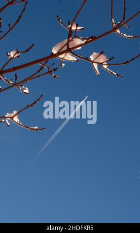 Un aereo da passeggeri a reazione lascia un contrail sulla sua scia mentre vola su un sudovest americano ghiacciato. Foto Stock