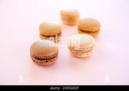 Macaron o macaron francesi con aroma di vaniglia, moka e cioccolato su sfondo rosa Foto Stock