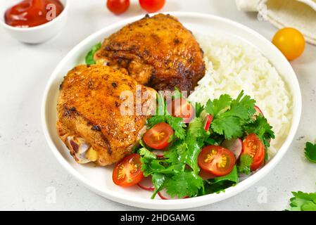 Cosce di pollo fritte con verdure e riso sul piatto Foto Stock