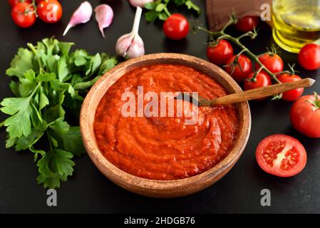 Salsa di pomodoro fatta in casa in ciotola di legno Foto Stock