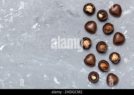 Diversi tipi di cioccolatini su un tavolo colorato da vicino. Vista dall'alto e disposizione piatta con spazio di copia. Foto Stock