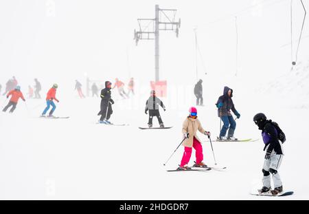 Sciatori e snowboarder presso il Glenshee Snowsports Centre, Cairnwell, Aberdeenshire. Gli esperti di previsioni meteorologiche prevedono nuove cadute di neve in tutta la Scozia e nel nord dell'Inghilterra. Data foto: Giovedì 6 gennaio 2022. Foto Stock