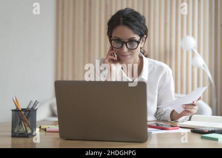 Sorridente donna di affari sicura lavora sul calcolatore nel paese, consultando i clienti in modo distante in linea Foto Stock