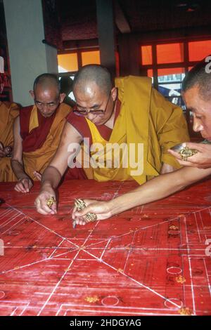 H.H. Dalai lama con monaci che delineano il mandala di sabbia rituale durante la cerimonia di iniziazione di Kalachakra nel 1984. Bodh Gaya, Bihar, India Foto Stock