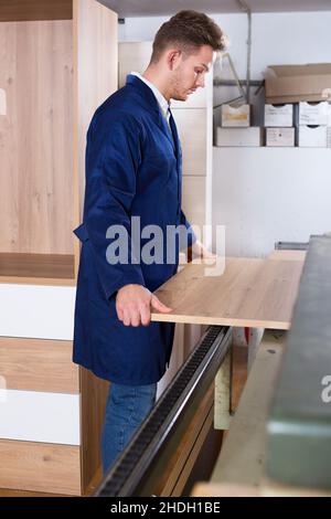 Uomo di lavoro che prepara il truciolare per il lavoro Foto Stock