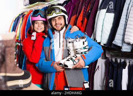 Uomo e donna in piedi con attrezzatura da sci acquistata in negozio Foto Stock