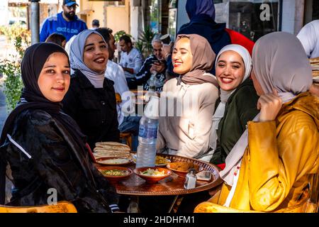 Un gruppo di giovani donne giordane godersi la colazione fuori Da Un caffè in Aqaba, governatorato di Aqaba, Giordania. Foto Stock