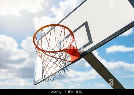 Canestro da basket sotto il cielo blu con le nuvole Foto Stock