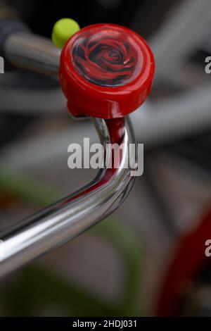 Campana della bicicletta di rose. Manubrio della bicicletta con campana con sfondo sfocato. Foto Stock