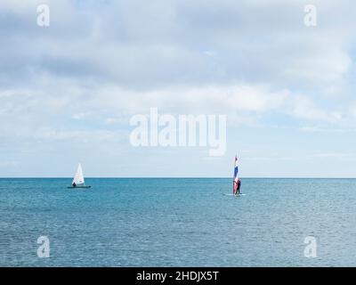 Due barche a vela navigano nelle acque calme di Fuengirola in una giornata invernale nuvolosa. Foto Stock