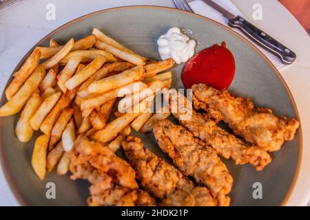 Pasto nella Repubblica Dominicana. Patatine fritte con strisce di pollo alla Pechurina Foto Stock