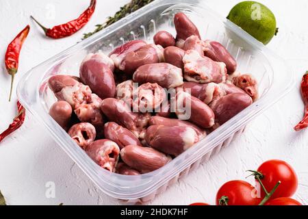 Cuori di pollo crudo fresco in confezione di plastica, su sfondo bianco tavolo di pietra Foto Stock