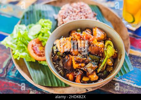 Popolare pasto Balinese di riso con varietà di piatti laterali che sono serviti insieme con il riso e più come extra opzionali Foto Stock