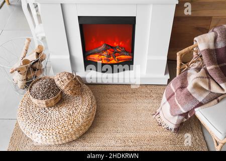 Cestino di vimini con legno vicino al caminetto in camera Foto stock - Alamy