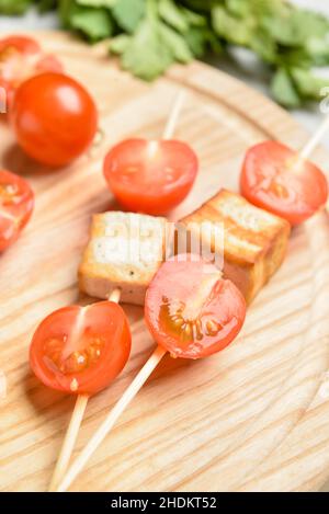 Bordo con spiedini di formaggio tofu alla griglia e verdure, closeup Foto Stock