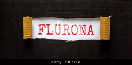 Covid-19 corona e influenza flurona simbolo. La parola di concetto flurona che appare dietro carta nera strappata. Bellissimo sfondo bianco e nero. Medico, COV Foto Stock