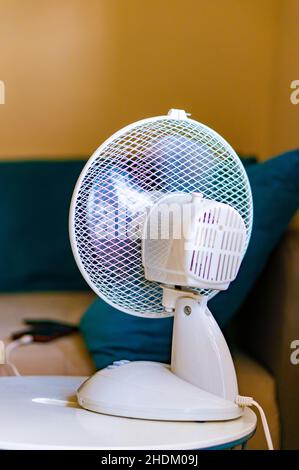 Scatto verticale di un piccolo ventilatore bianco in una stanza Foto Stock