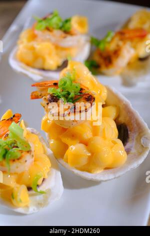 Fantasia matrimonio Hors d'oeuvres gamberi mac e formaggio servito in guscio di ostriche Foto Stock