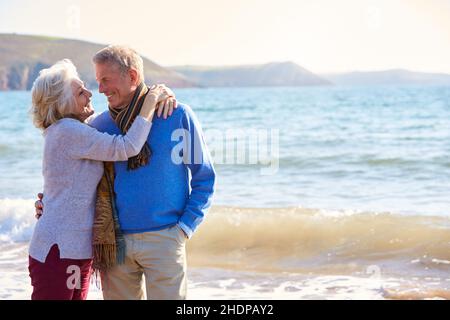 abbracciando, camminando in spiaggia, coppia più anziana, coccole, abbraccio, abbracciando, coppie più anziane Foto Stock