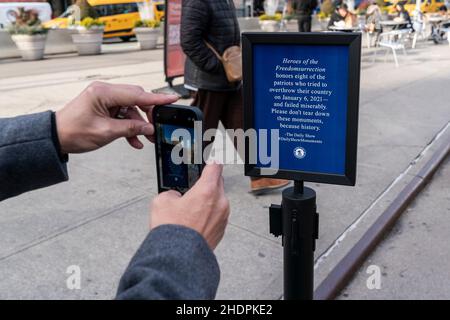 The Daily Show Monuments for Heroes of the Freedomsurrezione in anniversario di insurrezione al Campidoglio visto sulla piazza pedonale vicino al Madison Square Park a New York il 6 gennaio 2022. Una persona scatta una foto del cartello che spiega l'installazione artistica. I 8 monumenti recitavano Rudy Giuliani, Tucker Carlson, Steve Bannon, il senatore Josh Hawley, il senatore Ted Cruz, Rappresentante degli Stati Uniti Lauren Boebert, rappresentante degli Stati Uniti Marjorie Taylor Greene, ex presidente Donald J. Trump. Tutti i monumenti sono stati progettati per assomiglia a lapidi. (Foto di Lev Radin/Sipa USA) Foto Stock