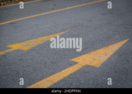 Due frecce gialle vecchio e nuovo directionon asfalto fondo strada Foto Stock