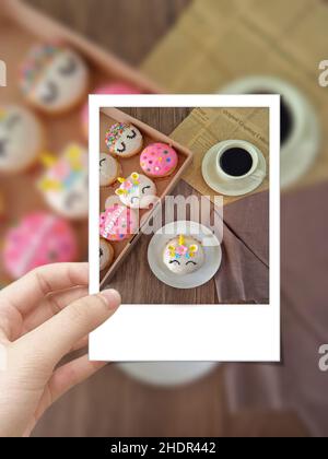 Unicorno ciambelle e una tazza di caffè su un tavolo di legno Foto Stock