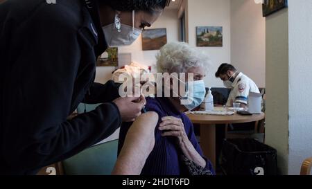 Gerusalemme, Israele. 6th Jan 2022. Un paramedico del Magen David Adom, il servizio medico di emergenza nazionale israeliano, amministra il vaccino Pfizer-BioNTech COVID-19 ad una donna israeliana anziana nella casa di cura di Migdal Nofim mentre Israele diventa il primo paese al mondo ad intraprendere una quarta campagna di vaccinazione COVID-19 il 6 gennaio 2022 a Gerusalemme, Israele. Israele ha iniziato a somministrare quarta dose di vaccino contro il coronavirus di Pfizer a persone di età superiore ai 60 anni e agli operatori sanitari, come parte degli sforzi per arginare il rapido aumento dei tassi di infezione causato dalla variante Omicron. Credit: Eddie Gerald Foto Stock