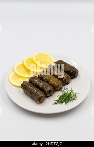 Foglie d'uva farcite con olio d'oliva su sfondo bianco. Prelibatezze della cucina tradizionale turca. Delicious dolma (yaprak sarma). Vista verticale. Clos Foto Stock
