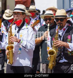 cuenca, Ecuador, 24 dicembre 2021 - gli uomini giocano il saxiphone nella tradizionale Parata itinerante della vigilia di Natale di Pase del Nino. Foto Stock