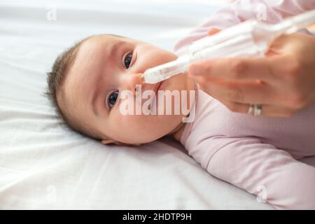 Madre con bambino elettrico Aspiratore nasale. Lei sta facendo una  aspirazione di muco per venti mesi baby boy Foto stock - Alamy