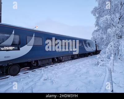 Un treno Caledonian Sleeper passa attraverso una stazione di Rannoch coperta di neve lungo il tragitto da Londra a Fort William. Data foto: Venerdì 7 gennaio 2022. Foto Stock