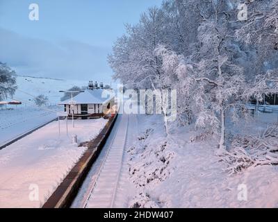 Un operatore ferroviario libera la neve dalla piattaforma della stazione di Rannoch sulla West Highland Line che corre da Glasgow a Oban o Fort William. Data foto: Venerdì 7 gennaio 2022. Foto Stock