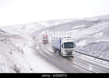 I veicoli navigano sulla neve fresca caduta su A628 al passo Woodhead. Data foto: Venerdì 7 gennaio 2022. Foto Stock