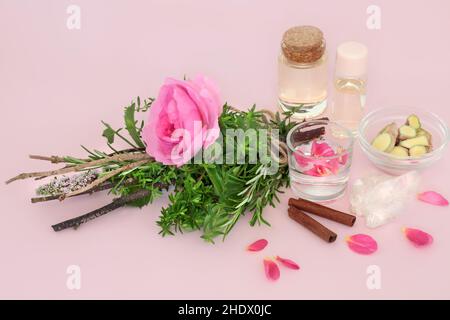 Le streghe amano la pozione preparazione con fiore di rosa e pacchetto di erbe, cristallo di quarzo, acqua di sorgente, bottiglie di olio, zenzero e cannella spezia su rosa. Foto Stock