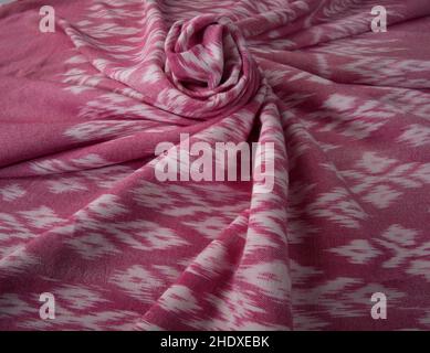 Primo piano della texture di colore rosa tessuto di cotone intessuto a mano in stile Thai antico. Foto Stock