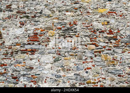 Primo piano di un antico muro in pietra e mattoni, con diverse texture e colori, Genova, Liguria, Italia Foto Stock