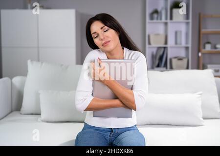 Divertimento con abbraccio virtuale. Donna felice sorridente portatile di tenuta Foto Stock