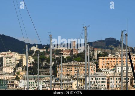 Paesaggio urbano dal porto con il Castello di Coppedè sulla collina e alberi di barche a vela in primo piano, Genova, Liguria, Italia Foto Stock